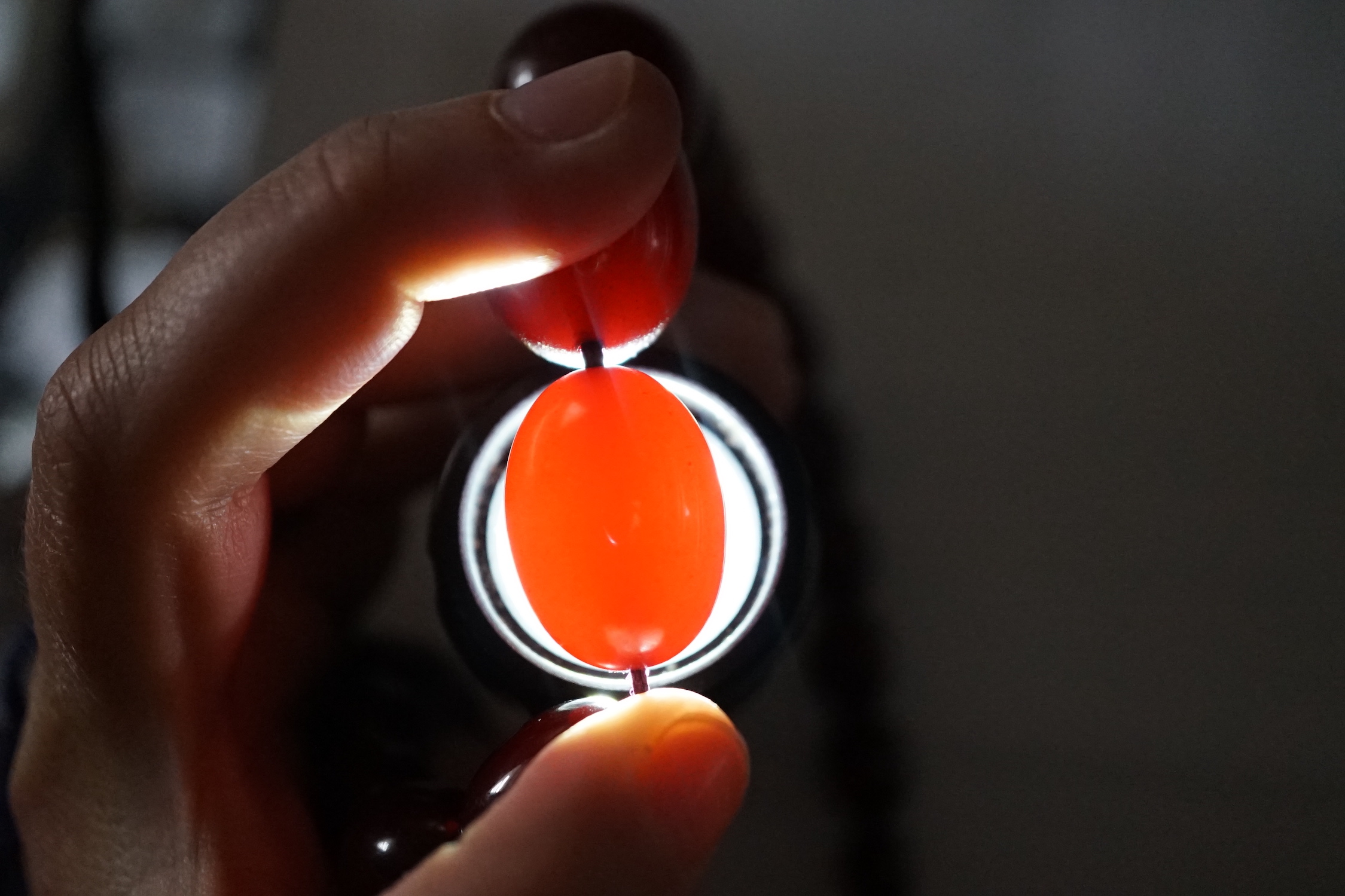 A single strand graduated simulated cherry amber necklace, one other necklace and some loose beads